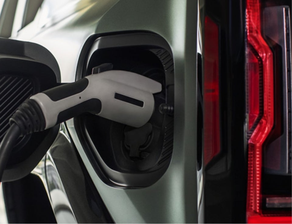 Close up of charging port with charger plugged in on a GMC Hummer EV SUV - Cardinale GMC in Seaside CA